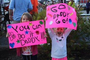 Andrew Estey’s children Grace, left, and Charlotte, hold signs of encouragement during the 2014 Marathon by the Sea half marathon in Saint John last August.