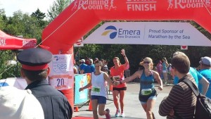 From left to right, Carol Lynn Landry, Renee Landry and Shelley Kirkpatrick cross the finish line at the 2014 Marathon by the Sea half marathon.