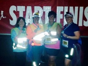 Patty MacMillan, right, celebrates with friends after completing the Into  The Night 5 k Friday